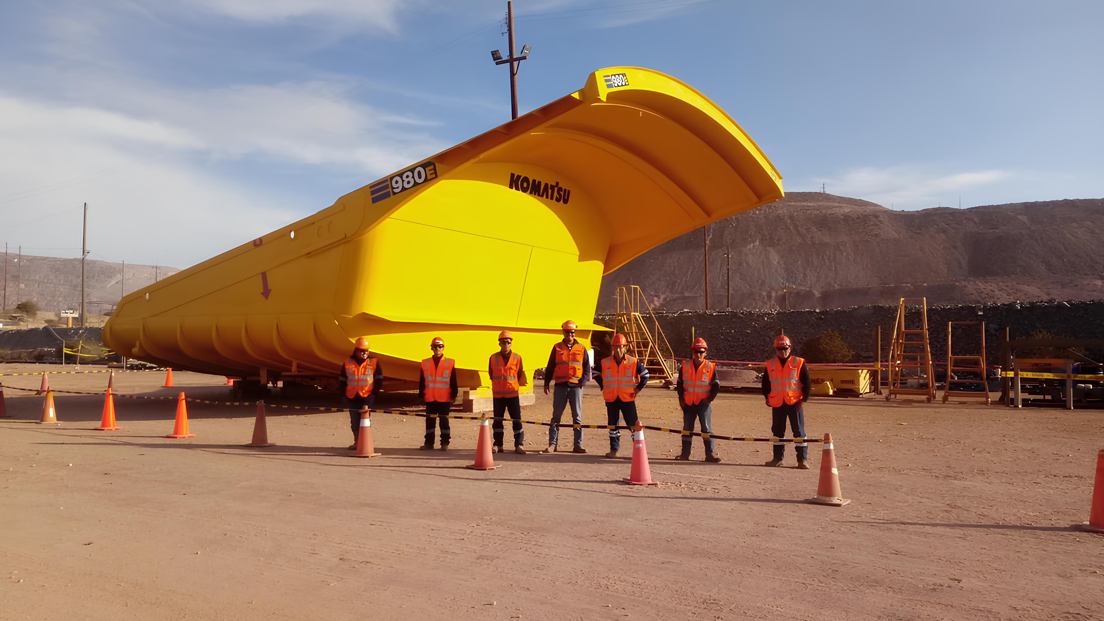 Equipo de MDN junto a una tolva Komatsu 980E en operación minera